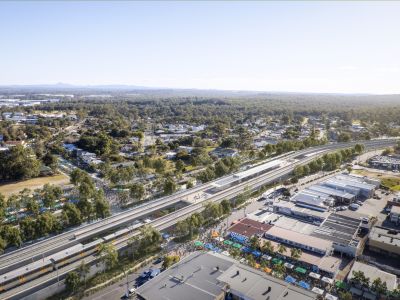 Aerial view of elevated train station surrounded by shops and businesses.